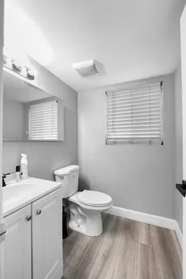 a white bathroom with a toilet and a sink at Spacious 4-bedroom Glendora Super House in Glendora