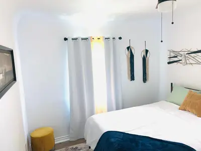 a bedroom with a bed and a window with curtains at Cozy Home Away From Home in Mojave