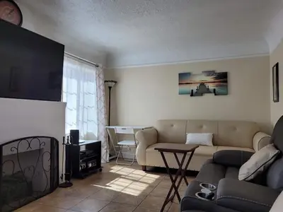 a living room with a couch and a table at Cozy Spacious, free parking, near it all in South Gate