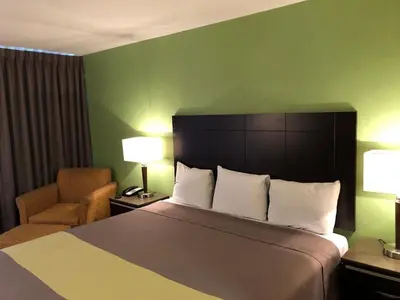 a hotel room with a large bed and a chair at Inn Of Long Beach in Long Beach