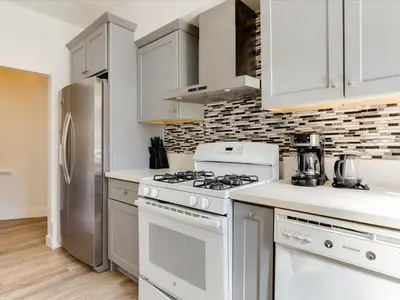 a white kitchen with a stove and a refrigerator at Modern 3 Bedroom Apartment in San Fernando in San Fernando
