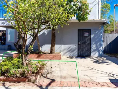 a house with a tree in front of a building at Modern 3 Bedroom Apartment in San Fernando in San Fernando