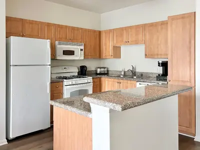 a kitchen with white appliances and wooden cabinets at 2BD 2BTH Apartment in Marina Del Rey - Free Parking - 20 mins to LAX in Los Angeles
