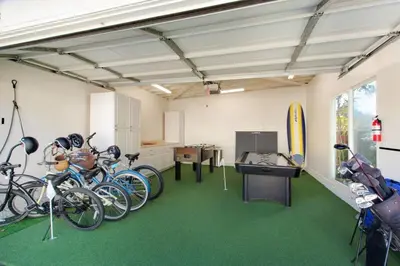 a garage with bikes parked in a room with green carpet at Beach Breeze Bungalow 1 Miles To Beach Cozy in Redondo Beach