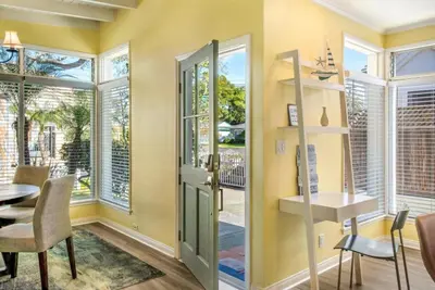 a dining room with a table and chairs and windows at Beach Breeze Bungalow 1 Miles To Beach Cozy in Redondo Beach