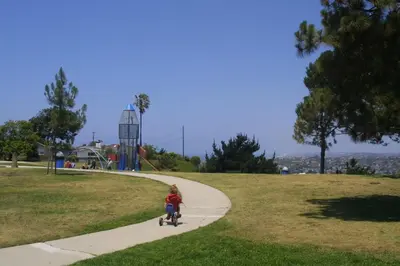a little girl riding a scooter down a sidewalk at Beach Breeze Bungalow 1 Miles To Beach Cozy in Redondo Beach