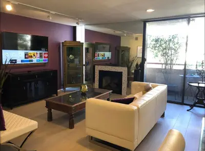 a living room with a white couch and a fireplace at Best Location West LA Spacious condo with hottub in Los Angeles