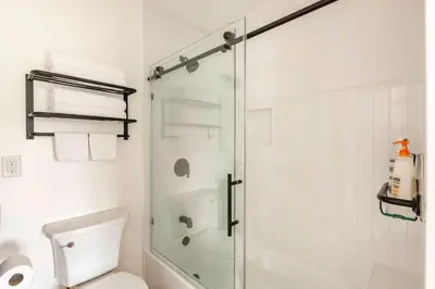 a bathroom with a toilet and a glass shower at Stylish Gated Retreat in East Hollywood with Parking in Los Angeles