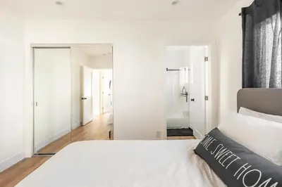 a bedroom with a white bed and a mirror at Stylish Gated Retreat in East Hollywood with Parking in Los Angeles