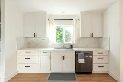 a kitchen with white cabinets and a sink and a window at Stylish Gated Retreat in East Hollywood with Parking in Los Angeles