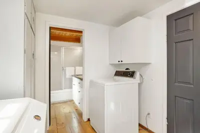 a white bathroom with a sink and a washing machine at Village Relaxation at Camp Conklin Big Bear - Hot Tub in Big Bear Lake