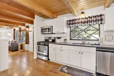 a kitchen with white cabinets and a stove top oven at Village Relaxation at Camp Conklin Big Bear - Hot Tub in Big Bear Lake