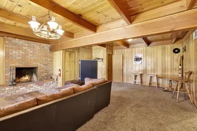 a living room with a large couch and a fireplace at Inspiration Point Retreat by Big Bear Vacations in Big Bear Lake