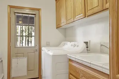 a white laundry room with a sink and a washing machine at Eagle Point Lake House by Big Bear Vacations in Big Bear Lake