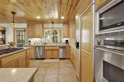 a kitchen with wooden cabinets and stainless steel appliances at Eagle Point Lake House by Big Bear Vacations in Big Bear Lake