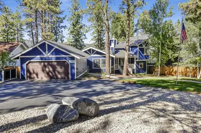 a blue house with rocks in the driveway at Serenity Cove Lake House by Big Bear Vacations in Big Bear Lake