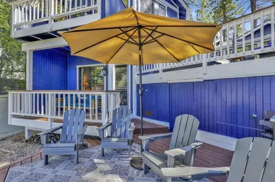 a patio with chairs and an umbrella on a house at Serenity Cove Lake House by Big Bear Vacations in Big Bear Lake