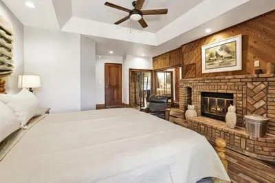 a bedroom with a large bed and a fireplace at Serenity Cove Lake House by Big Bear Vacations in Big Bear Lake