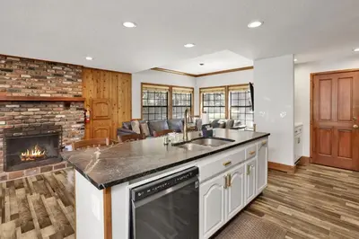 a kitchen with a sink and a fireplace at Serenity Cove Lake House by Big Bear Vacations in Big Bear Lake