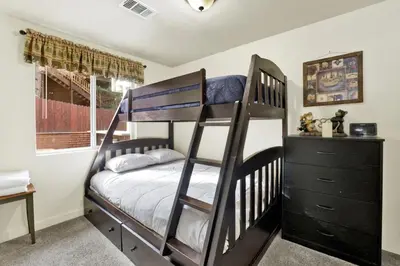 a bedroom with two bunk beds and a dresser at Green Squirrel Chateau by Big Bear Vacations in Big Bear Lake