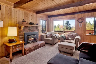 a living room with a fireplace in a cabin at Mountain Hideaway on Maryland by Big Bear Vacations in Big Bear Lake