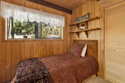 a bedroom with a bed in a wooden room at Mountain Hideaway on Maryland by Big Bear Vacations in Big Bear Lake