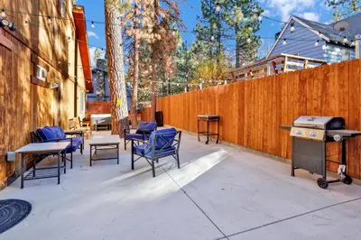 a patio with chairs and a grill and a fence at Temple Bear Chalet by Big Bear Vacations in Big Bear Lake