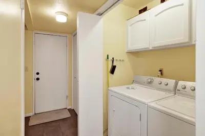 a white laundry room with a washer and dryer at Buttercup Snow Summit Condo by Big Bear Vacations in Big Bear Lake