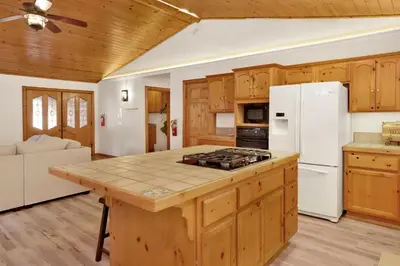 a kitchen with wooden cabinets and a white refrigerator at Oriole House- Walk to Lake Chalet w/ Hot Tub in Big Bear Lake