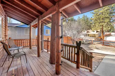 a porch with a rocking chair on a wooden deck at Oriole House- Walk to Lake Chalet w/ Hot Tub in Big Bear Lake