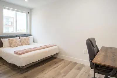 a bedroom with a bed and a desk and a table at Urban Oasis in the Heart of LA Near USC & Major Attractions in Los Angeles