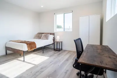 a bedroom with a bed and a desk and a table at Chic & Comfortable Space Near Downtown LA & USC in Los Angeles