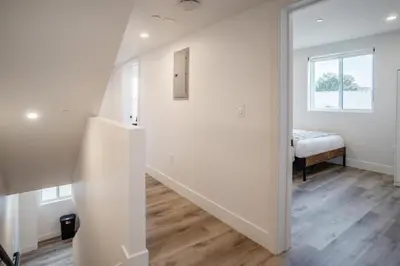 a white hallway with a stairway leading to a bedroom at Chic & Comfortable Space Near Downtown LA & USC in Los Angeles