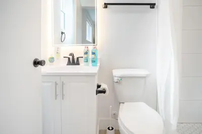 a white bathroom with a toilet and a sink at Chic & Comfortable Space Near Downtown LA & USC in Los Angeles