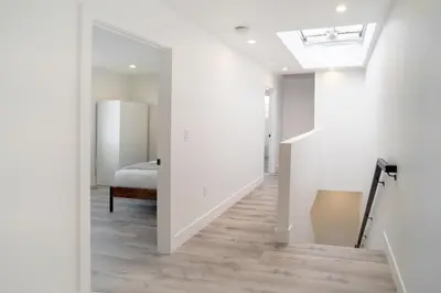 a hallway with a bed and a room with white walls at Stylish & Cozy Retreat Near USC & Downtown LA in Los Angeles