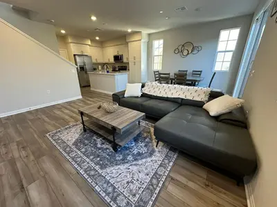 a living room with a black couch and a table at 3 bed 3 Bath Gated Corner unit in Upland