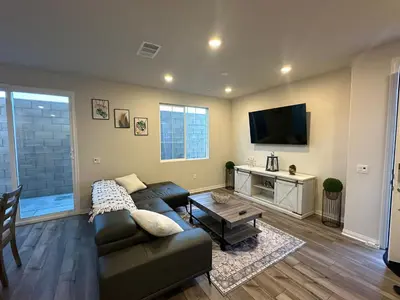 a living room with a couch and a flat screen tv at 3 bed 3 Bath Gated Corner unit in Upland