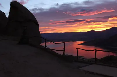 a sunset over a body of water with a fence at Epic View Hot tub National forest in Wofford Heights