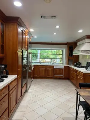 a large kitchen with wooden cabinets and a large window at Porter Paradise in Deer Lake Highlands