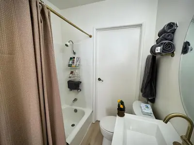 a bathroom with a toilet and a sink and a shower at gateway to the ocean in Hawthorne