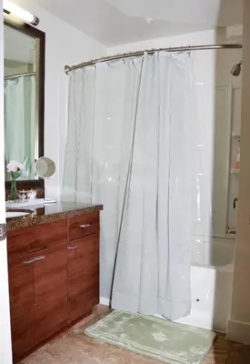 a bathroom with a shower with a white shower curtain at Studio Luxury Marina del Rey with parking gym pool in Los Angeles