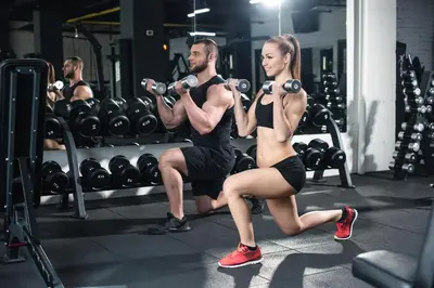a man and a woman lifting weights in a gym at Studio Luxury Marina del Rey with parking gym pool in Los Angeles