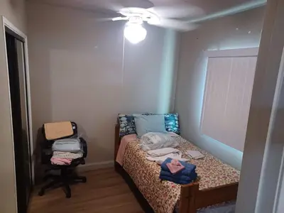 a small bedroom with a bed and a ceiling fan at Private room furnished Cypress in Lomita