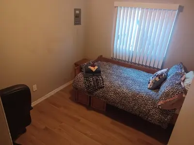 a bedroom with a leopard print bed and a window at Private room furnished Cypress in Lomita