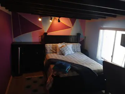 a bedroom with a bed with a geometric wall at Handcraft Cabin LAX Port of LA 20 min away in Lomita