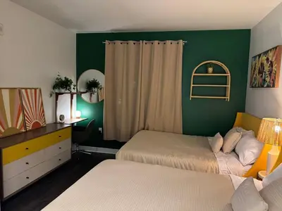 a bedroom with two beds and a green wall at Vibrant unit in Griffith in Glendale