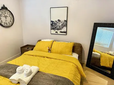 a bedroom with a bed with yellow sheets and towels at Modern & Spacious Family and Friend 4B3B House in Moreno Valley
