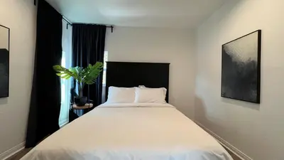 a bedroom with a large white bed with a black headboard at Spacious 3BR 3BA Home Private Yard in Culver City in Los Angeles