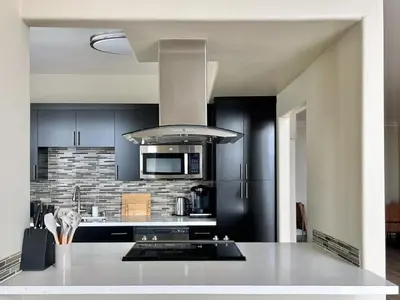 a kitchen with black cabinets and a white counter top at Modern Top Floor 3BD 3BA Condo Marina del Rey in Los Angeles