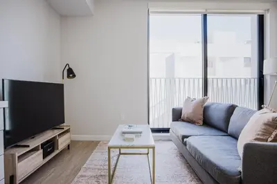 a living room with a blue couch and a tv at Blueground Downtown elevator nr The Broad LAX-1236 in Los Angeles